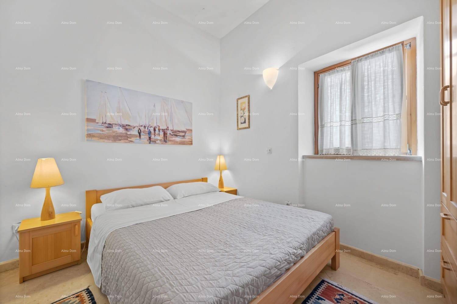 Helles Schlafzimmer mit Doppelbett, Holzmöbeln und einem Fenster für ausreichend Tageslicht.