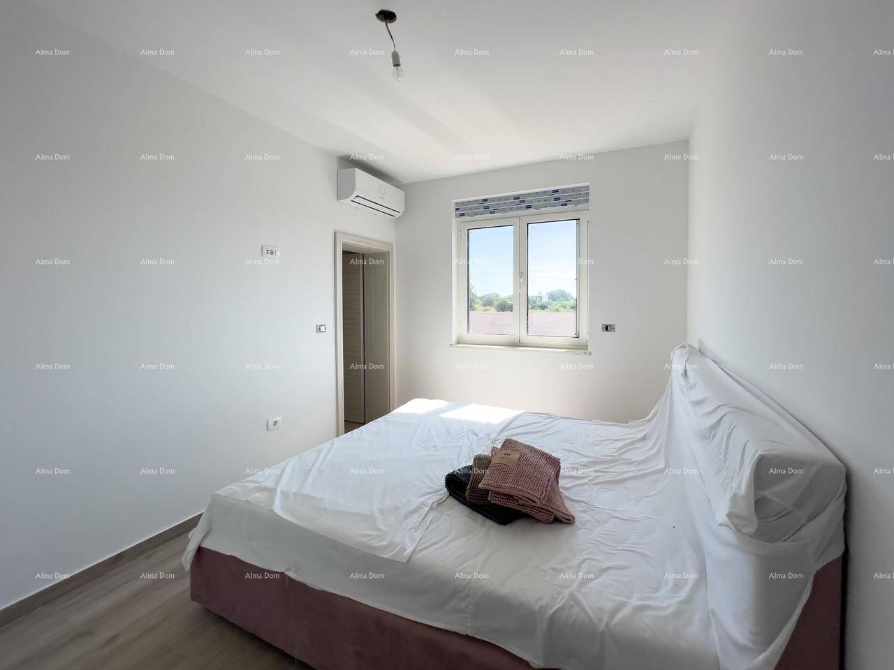 Helles Schlafzimmer mit Doppelbett, Klimaanlage und Fenster mit Blick ins Grüne.