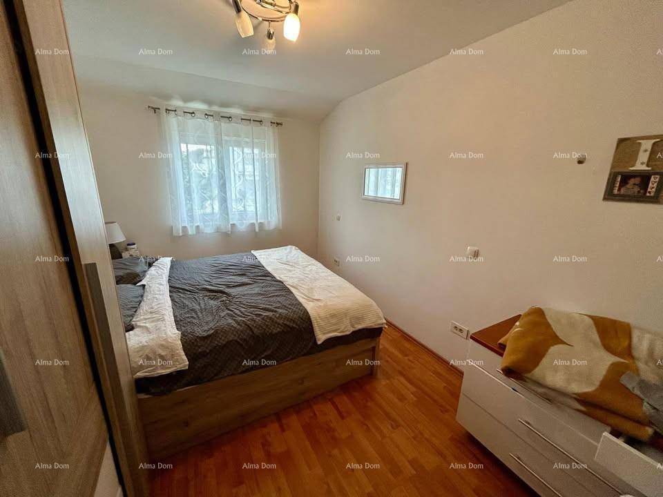 Helles Schlafzimmer mit Doppelbett, Fenster und warmem Holzboden.