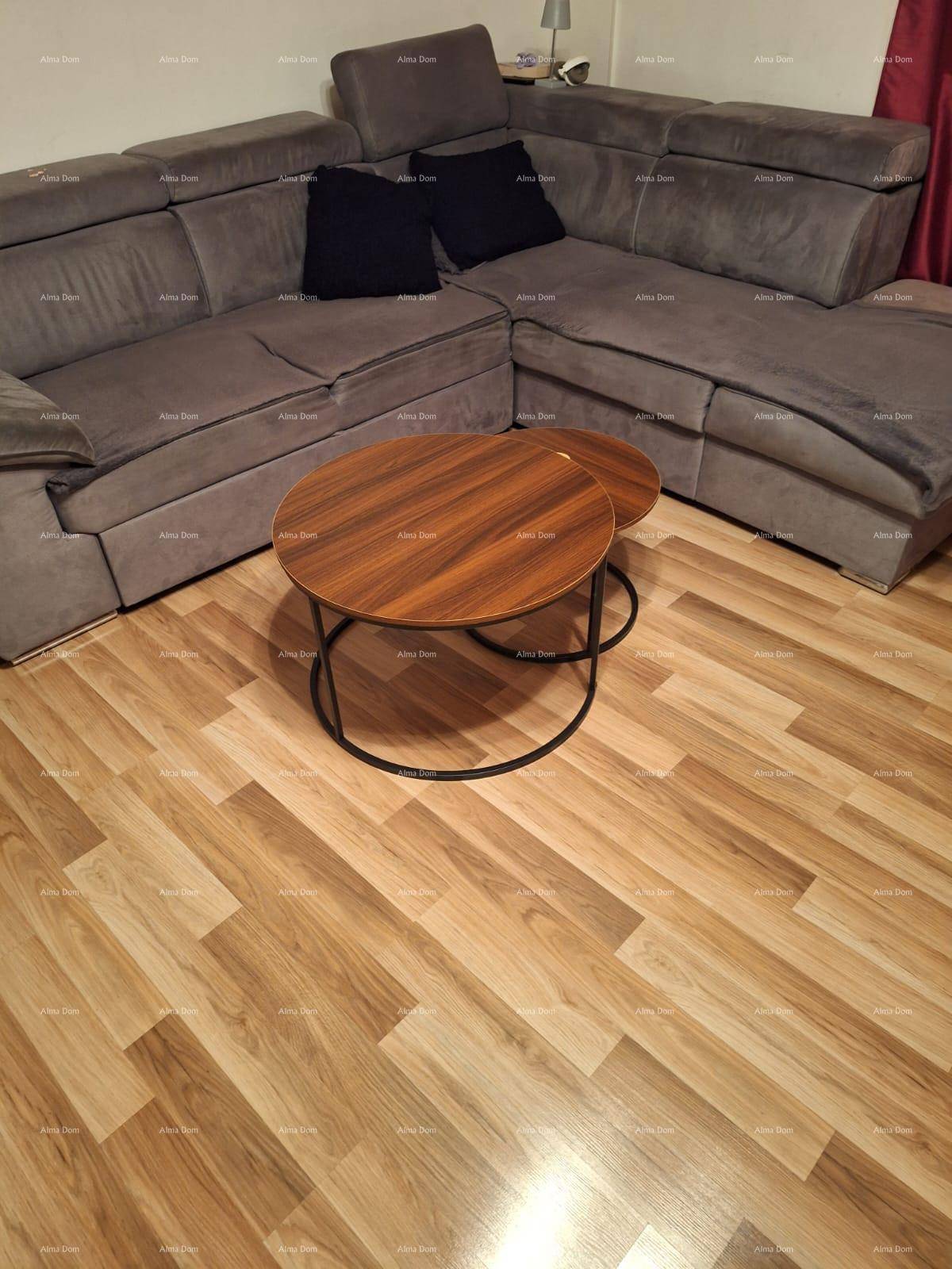 Gemütliches Wohnzimmer mit großem Ecksofa und zwei runden Couchtischen auf Laminatboden.