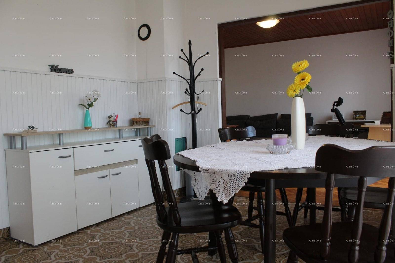 Heller Essbereich mit rundem Holztisch und Stühlen, offen zum angrenzenden Wohnzimmer.