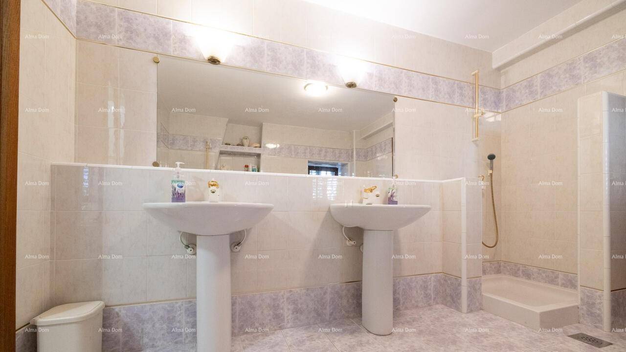 Badezimmer mit Doppelwaschbecken, großem Spiegel und Duschbereich.