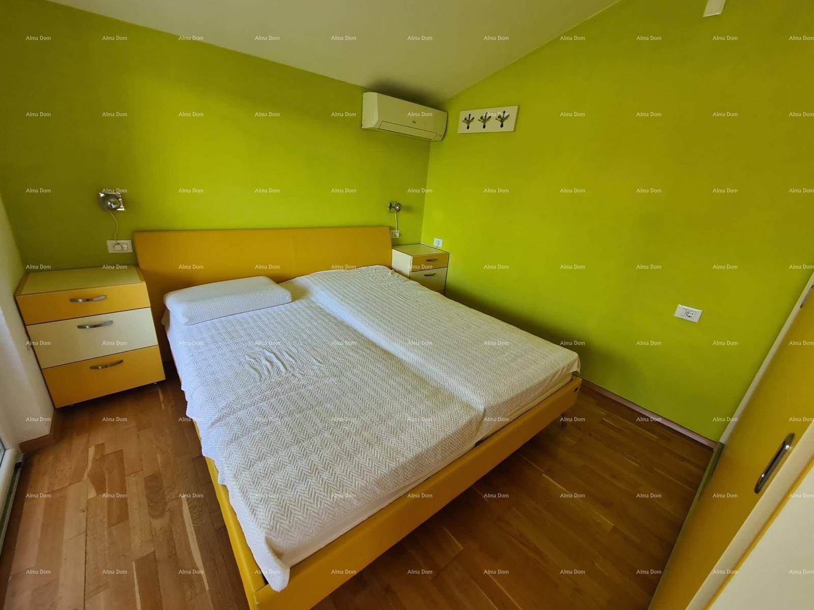 Helles Schlafzimmer mit Doppelbett, grünen Wänden und einem warmen Holzfußboden.