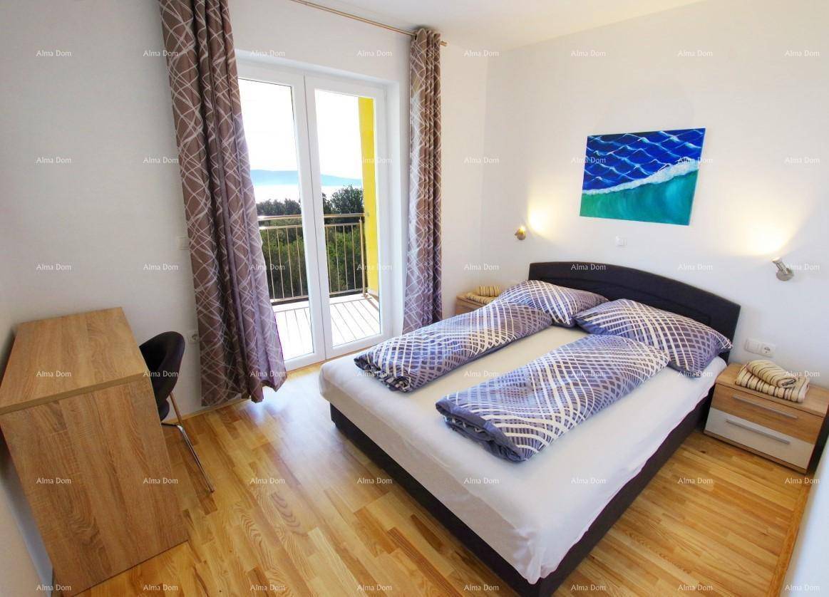 Gemütliches Schlafzimmer mit Holzboden, Doppelbett und Balkonzugang mit Blick ins Grüne.