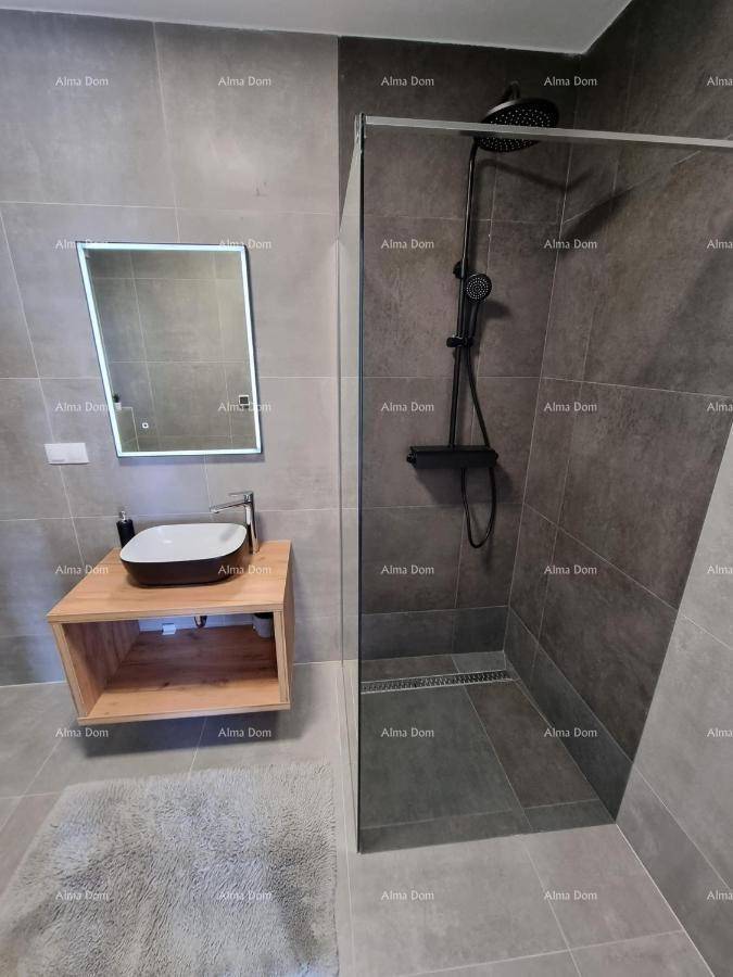 Modernes Badezimmer mit begehbarer Dusche, Aufsatzwaschbecken und beleuchtetem Spiegel.