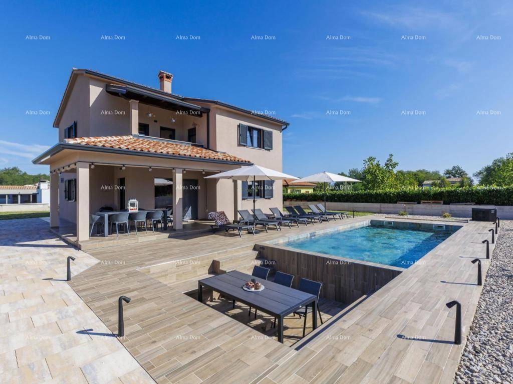 Modernes Haus mit großem Pool, Sonnenterrasse und Essbereich im Freien unter blauem Himmel.