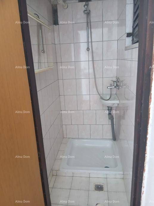 Kleines Badezimmer mit Duschkabine und weißen Fliesen, funktional und einfach gehalten.