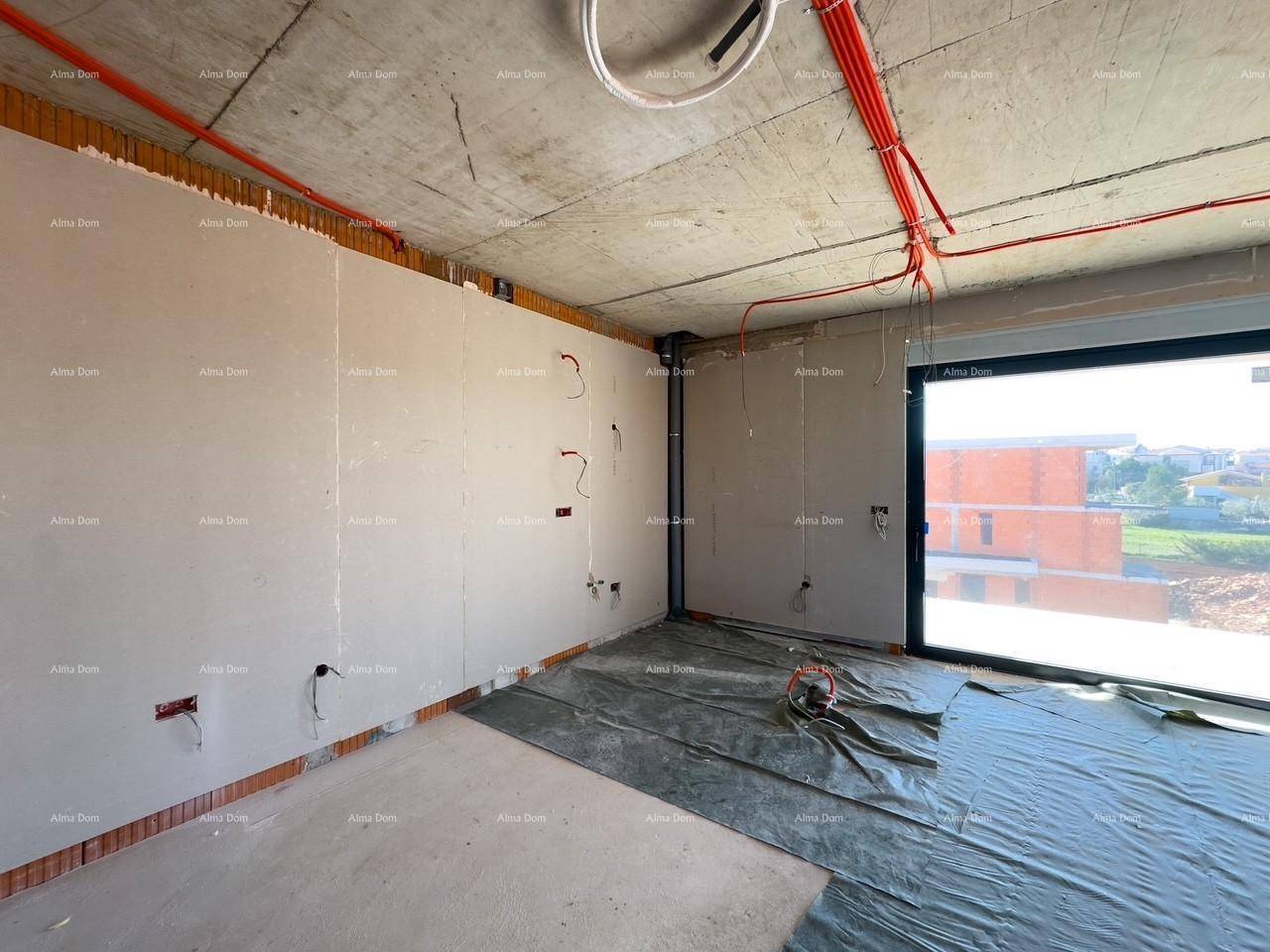 Rohbau-Wohnraum mit großen Fenstern und sichtbaren Elektroinstallationen an den Wänden und der Decke.