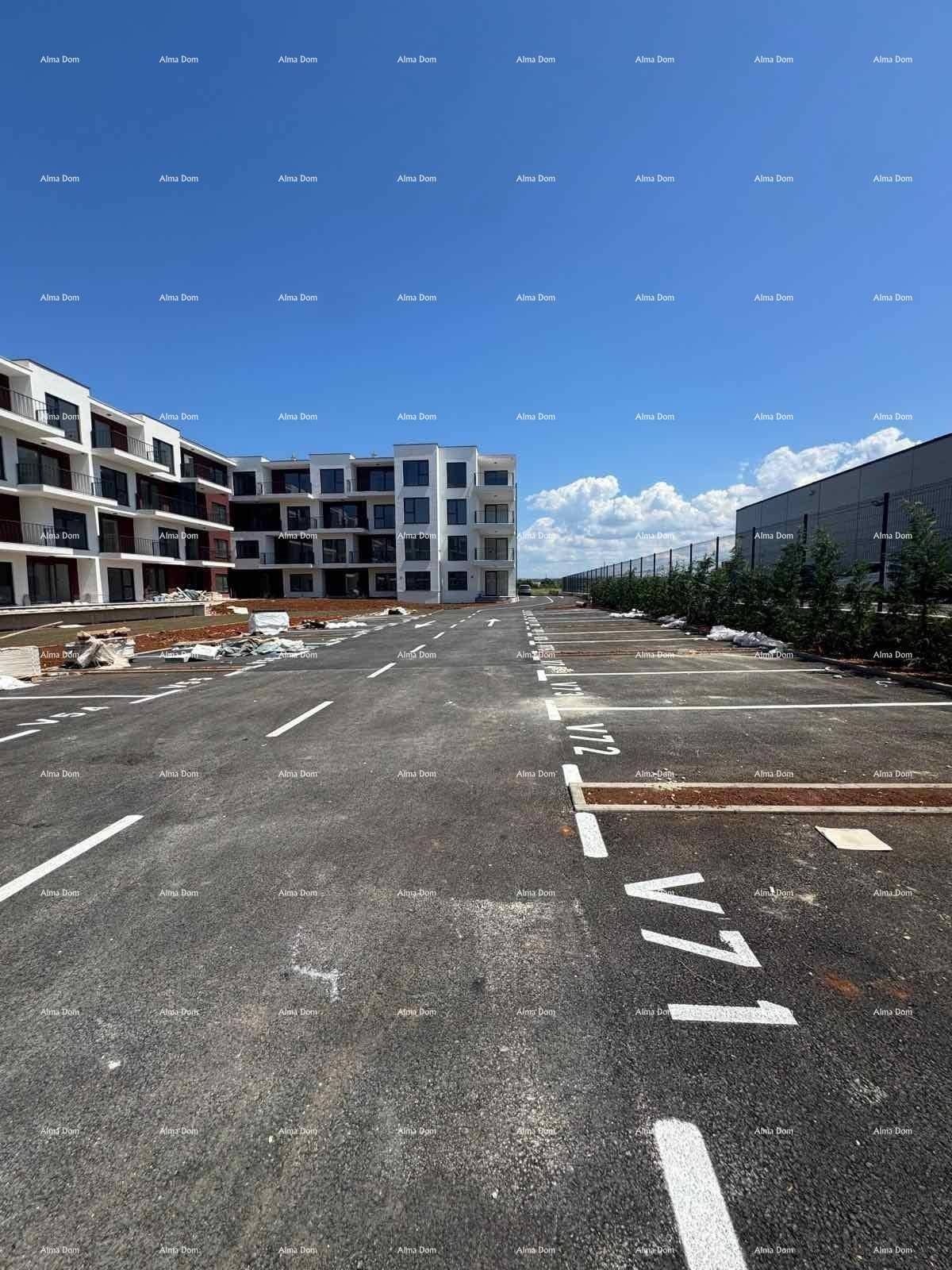 Großer Außenparkplatz mit Markierungen vor der modernen Wohnanlage unter klarem Himmel.