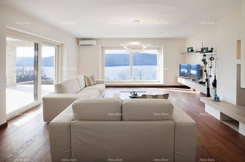 Geräumiges Wohnzimmer mit bequemen Sofas und einem weiten Blick auf den See.