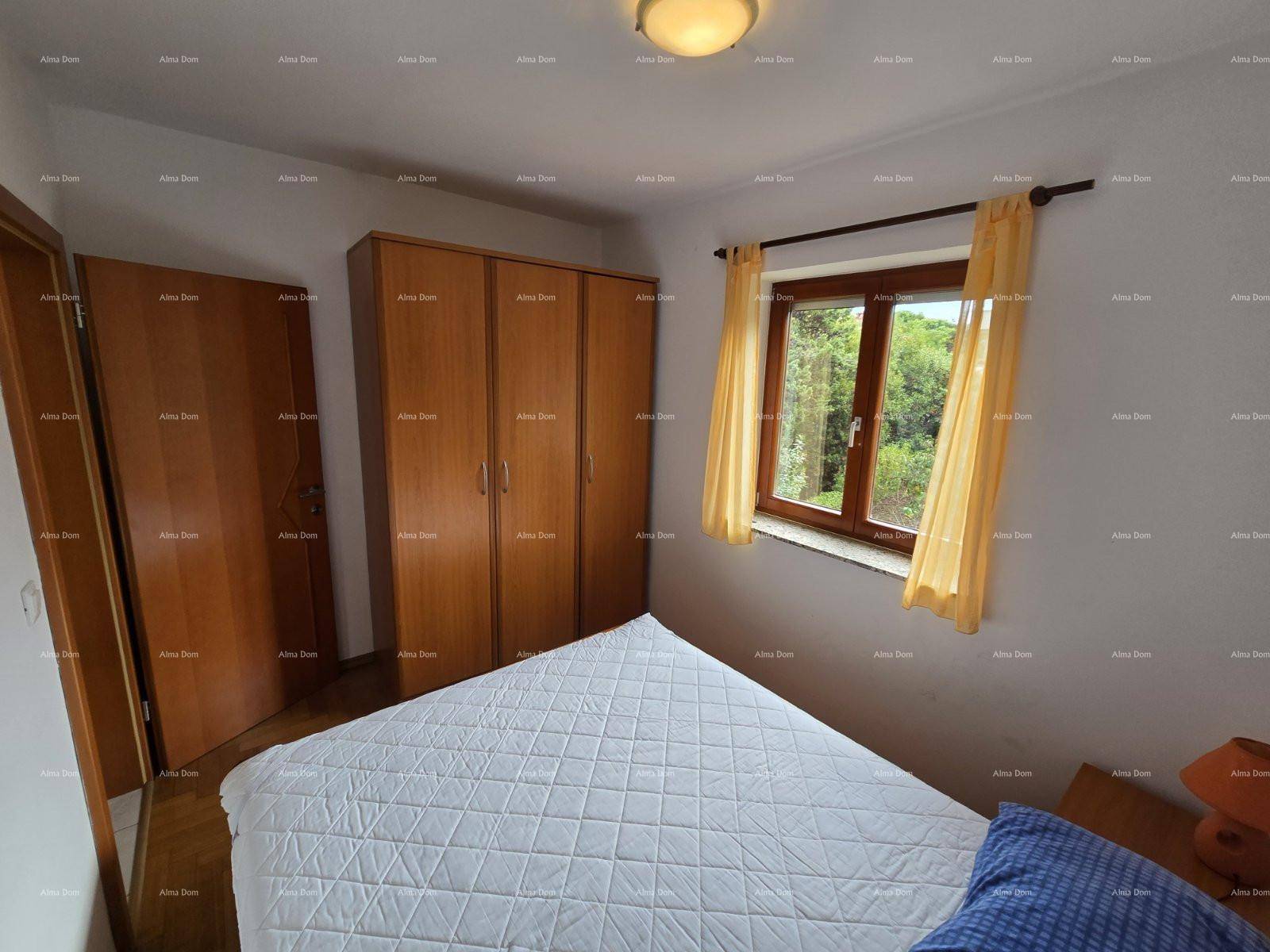 Gemütliches Schlafzimmer mit großem Holzschrank und Doppelbett, hell durch das Fenster.
