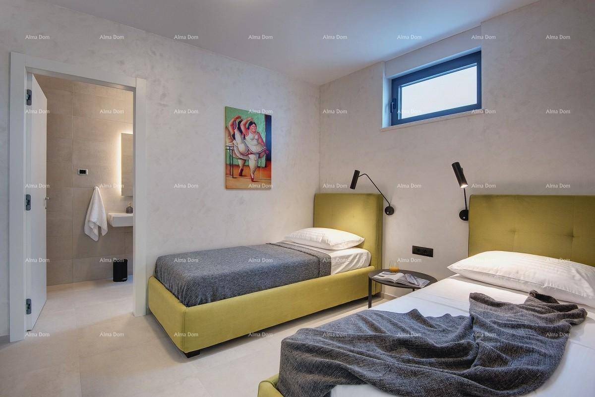 Helles Schlafzimmer mit zwei Einzelbetten, Holzboden und direktem Zugang zu einem eigenen Bad.