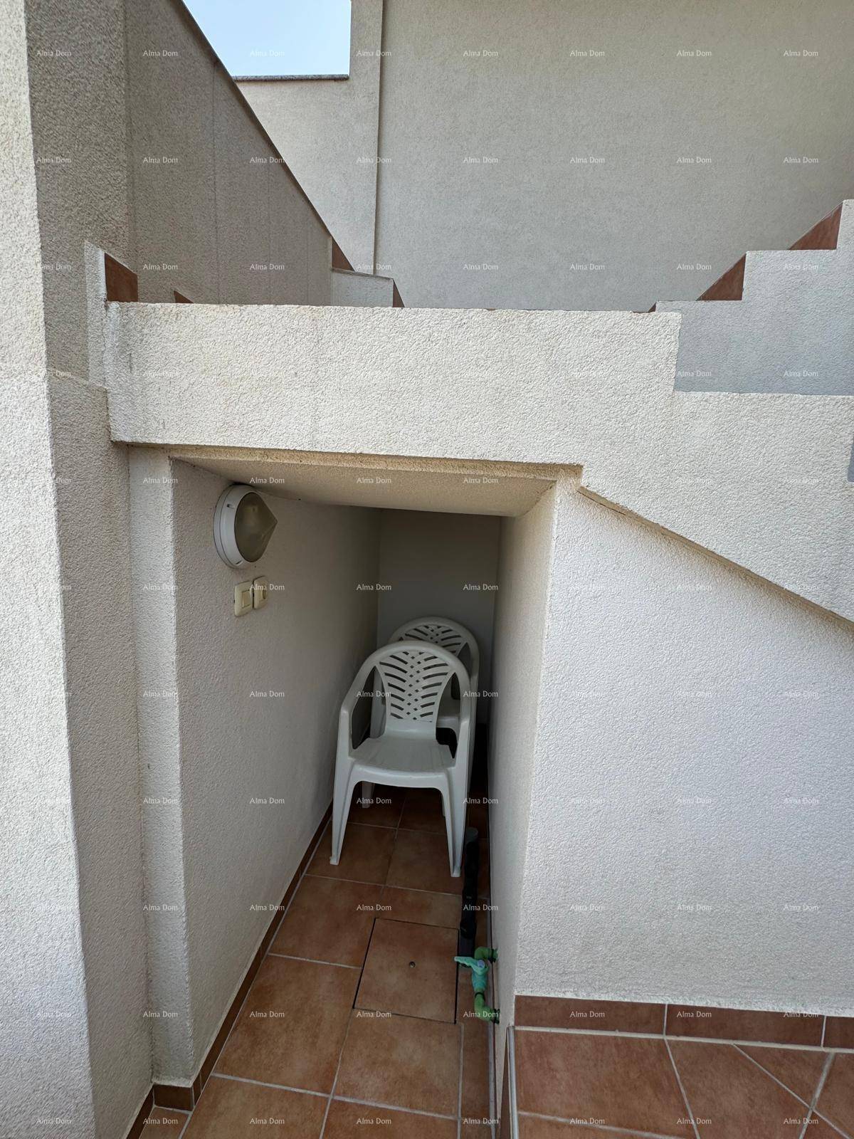 Kleiner Stauraum unter der Treppe mit einer weißen Plastikstuhl, funktional und praktisch.