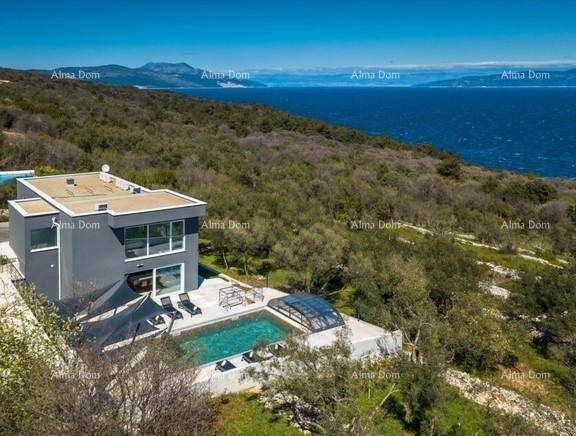 Moderne Villa mit Pool und Meerblick, umgeben von mediterraner Vegetation.
