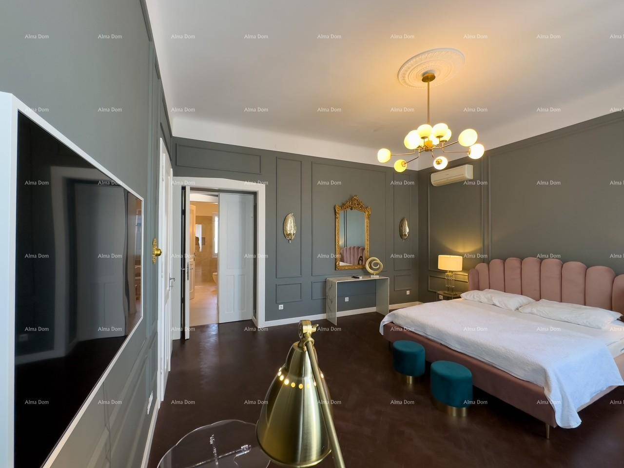 Stilvolles Schlafzimmer mit dunklem Parkettboden, Wandpaneelen und einem großen Fernseher an der Wand.