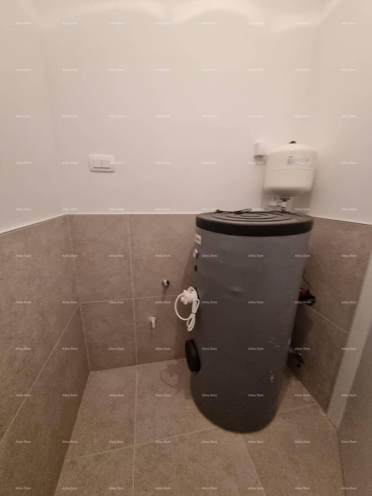 Praktischer Hauswirtschaftsraum mit Warmwasserspeicher und pflegeleichtem Fliesenboden.