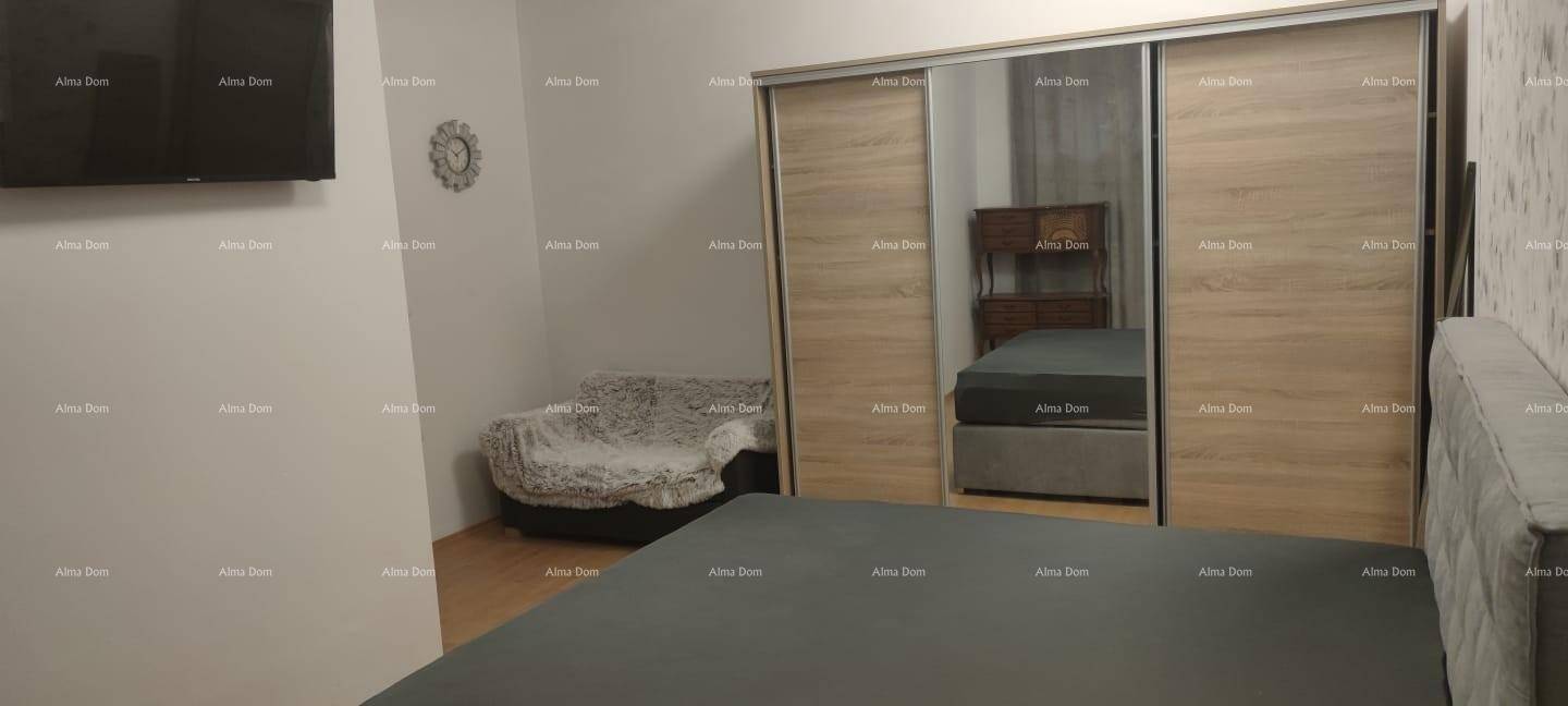 Schlafzimmer mit großem Bett, Wandfernseher und geräumigem Schiebetürenschrank mit Spiegeln.