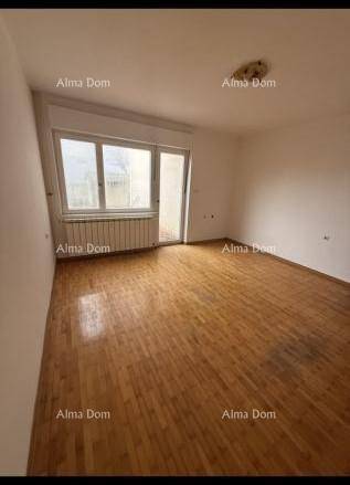 Geräumiges Wohnzimmer mit Holzparkettboden, weißen Wänden und Zugang zum Außenbereich.