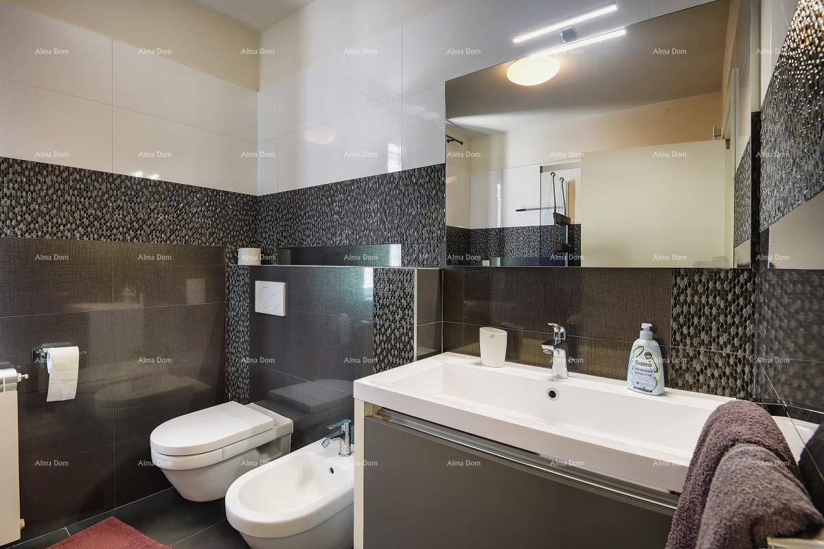 Modernes Badezimmer mit dunklen Fliesen, Einzelwaschbecken, Bidet und wandhängendem WC.