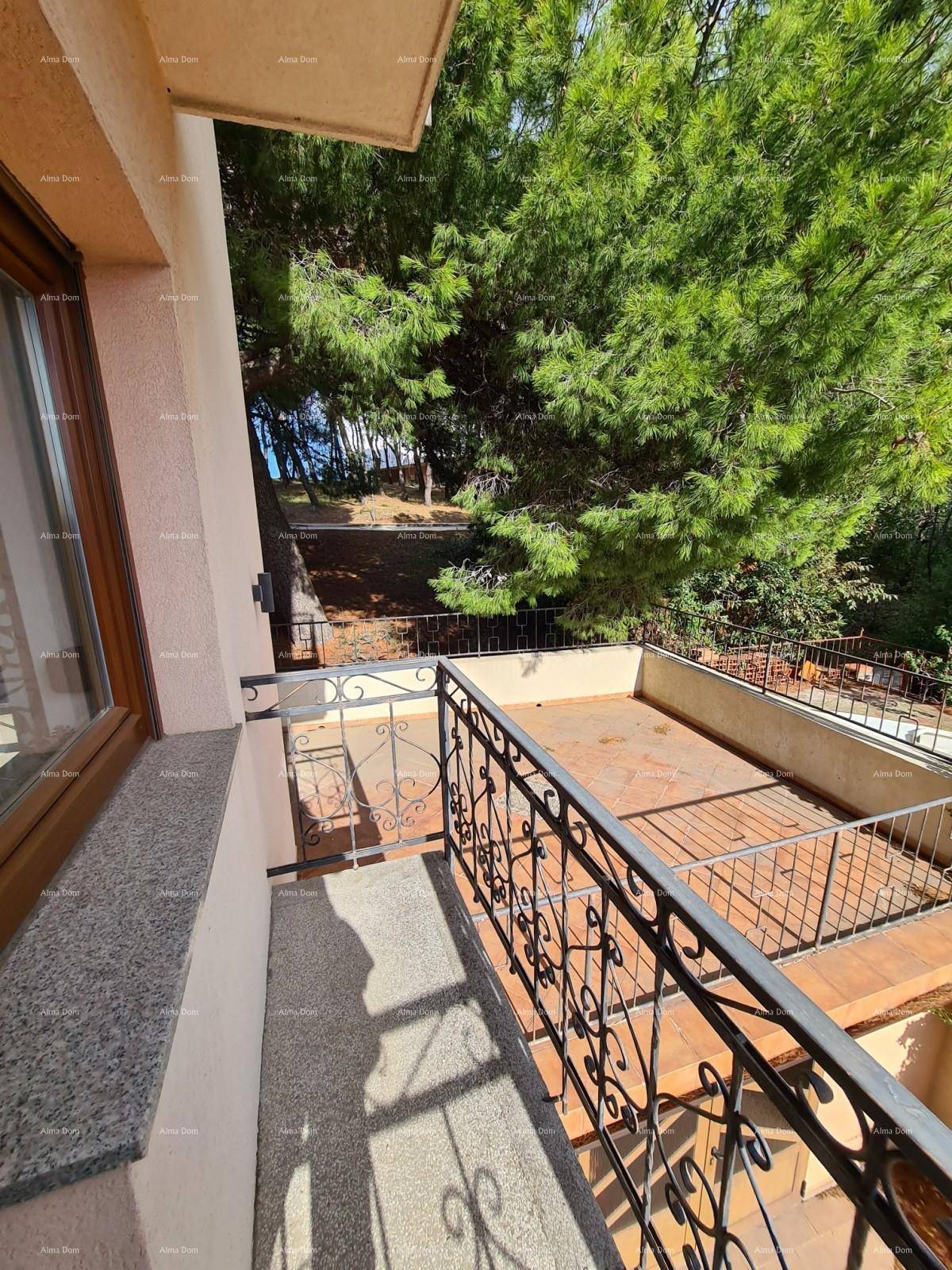 Kleiner Balkon mit schmiedeeisernem Geländer und Blick ins Grüne.