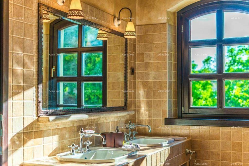 Helles Badezimmer mit zwei Waschbecken, gefliesten Wänden und einem Fenster mit Blick ins Grüne.