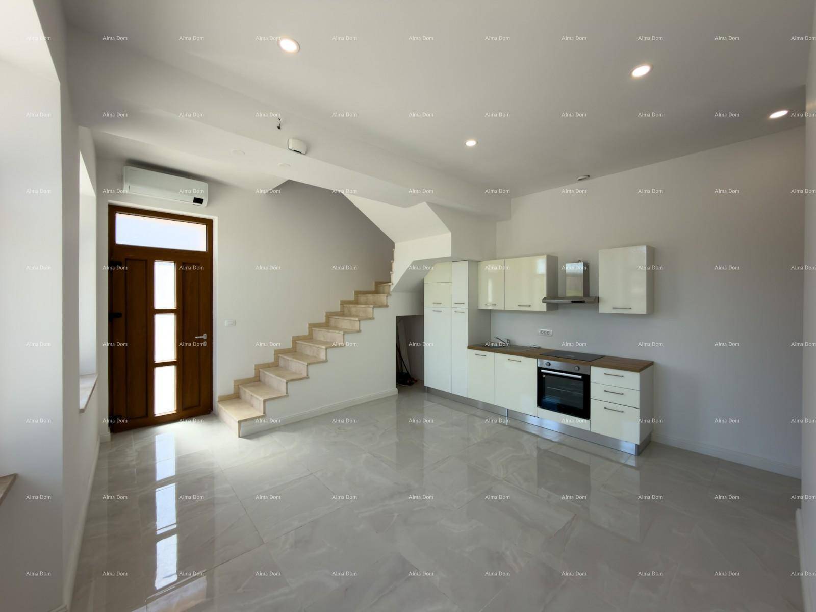 Heller, offener Wohnbereich mit integrierter Küche, Treppe und Eingangstür, modern gestaltet.
