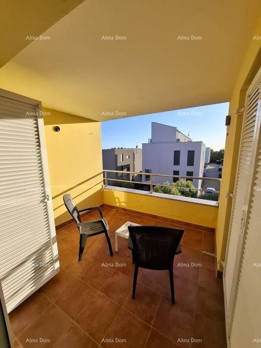 Heller Balkon mit Sitzgelegenheiten und Blick auf die umliegenden Gebäude und die Nachbarschaft.