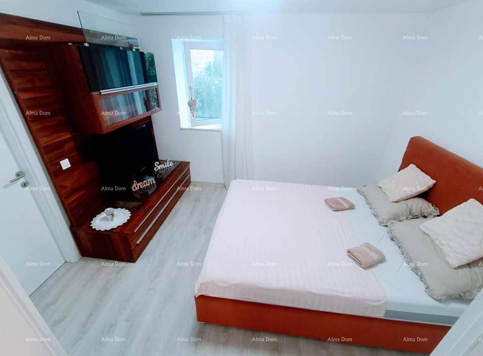 Schlafzimmer mit Doppelbett, elegantem Holzwandregal und Fenster für natürliches Licht.
