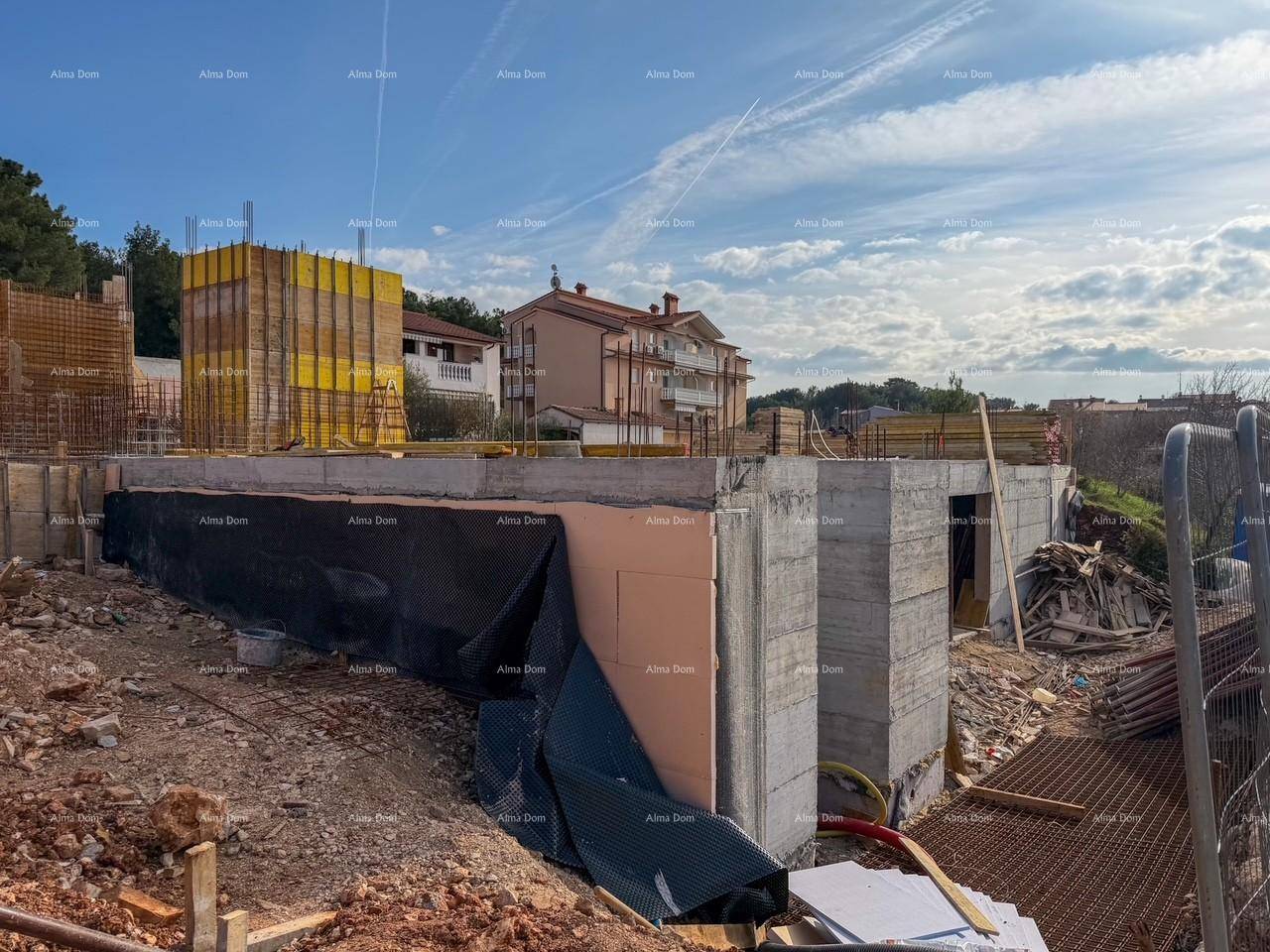 Baustelle mit Betonstrukturen und Baumaterialien unter blauem Himmel.