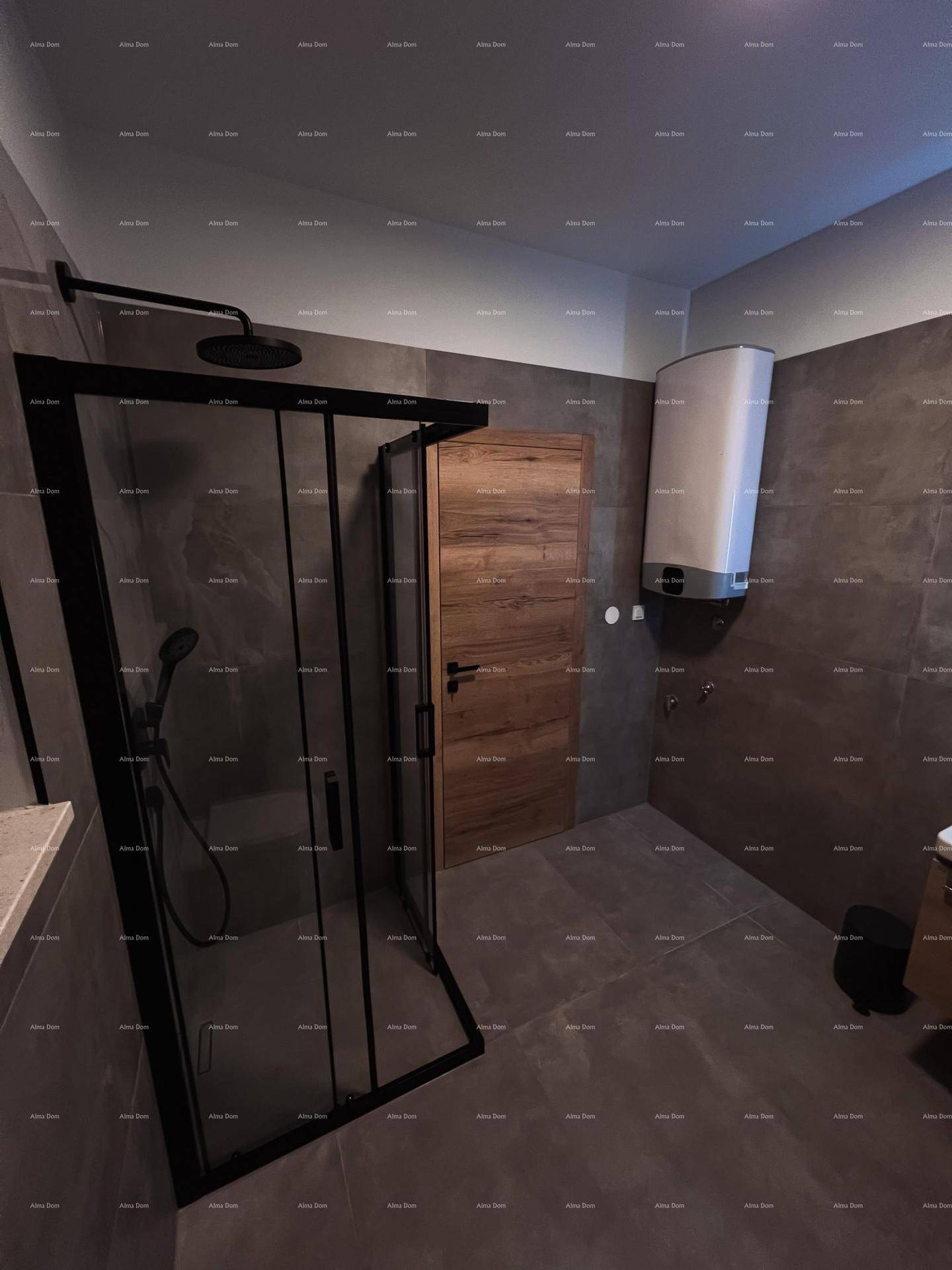 Geräumiges Badezimmer mit moderner Duschkabine, dunklen Fliesen und Warmwasserbereiter.
