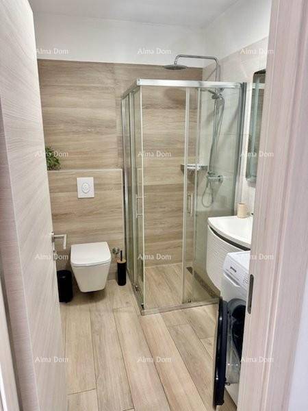 Helles Badezimmer mit Duschkabine, WC und Waschmaschine, vom Eingang aus gesehen.