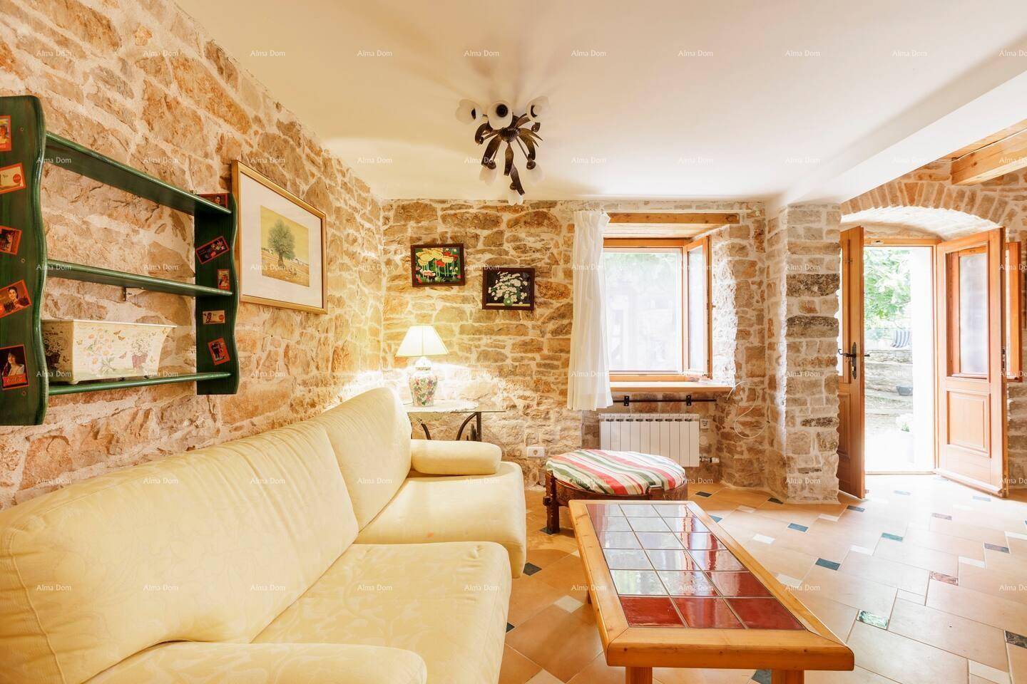 Gemütliches Wohnzimmer mit Steinwänden, Fliesenboden und bequemer Couch.