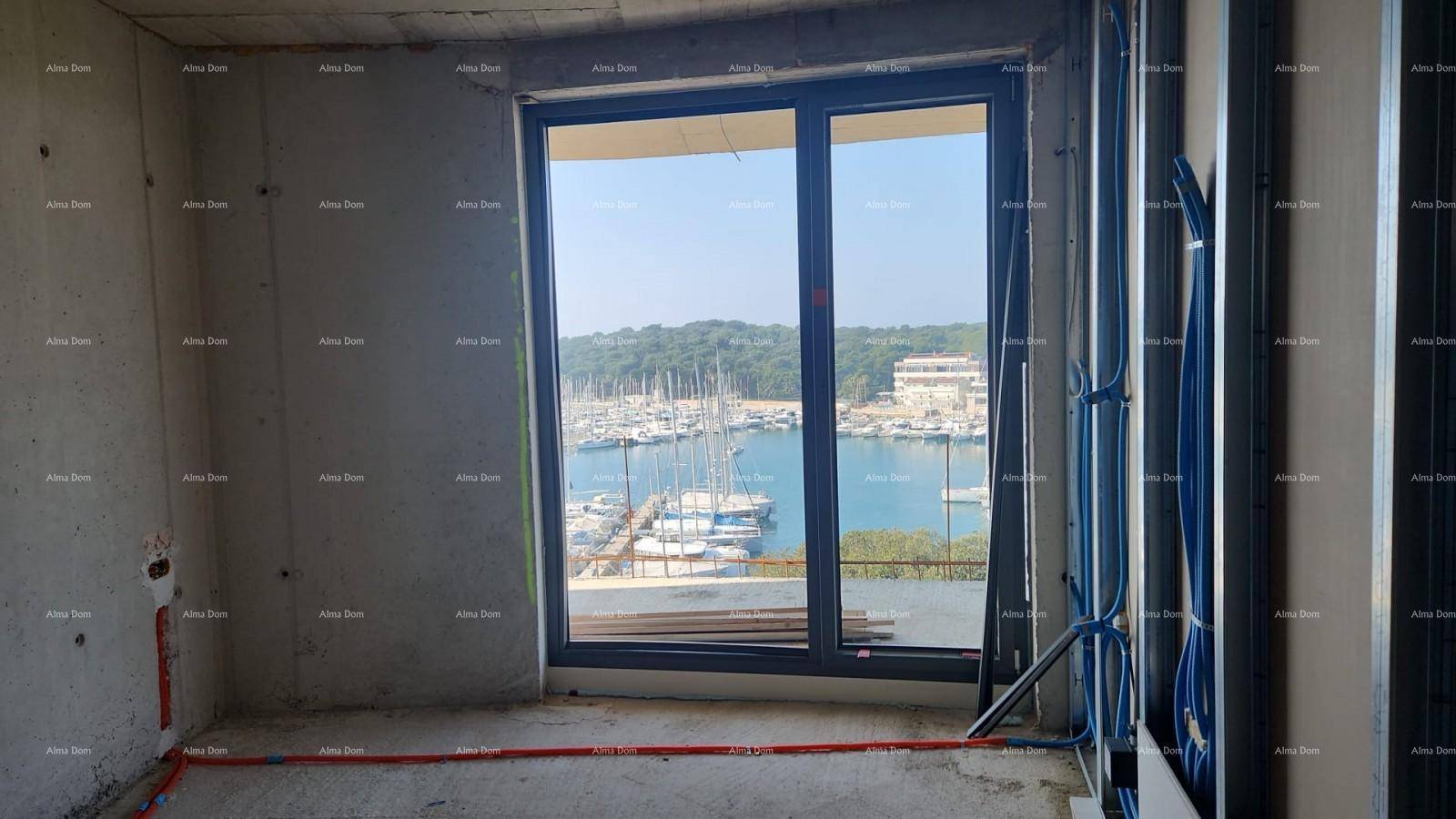 Unfertiger Raum mit Betonwänden, sichtbaren Leitungen und einem Fenster mit Blick auf den Yachthafen.
