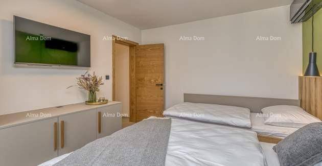 Schlafzimmer mit Doppelbett, Wandfernseher und Holztür, die zu einem anderen Raum führt.