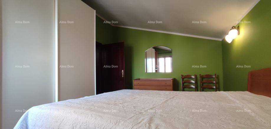 Schlafzimmer mit grün gestrichenen Wänden, Bett und Kommode.