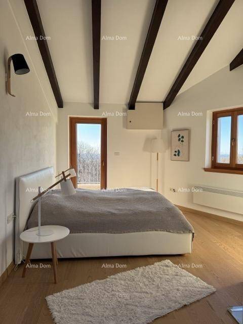 Helles Schlafzimmer mit Holzbalken an der Decke, modernem Bett und Zugang zu einem Balkon.