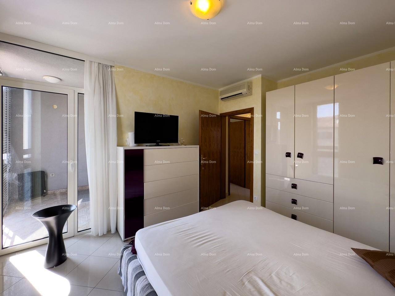 Schlafzimmer mit Bett, Fernseher und direktem Zugang zu einem sonnigen Balkon.