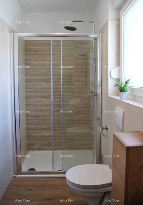 Modernes Badezimmer mit Duschkabine, wandhängendem WC und Fenster für natürliche Belüftung.