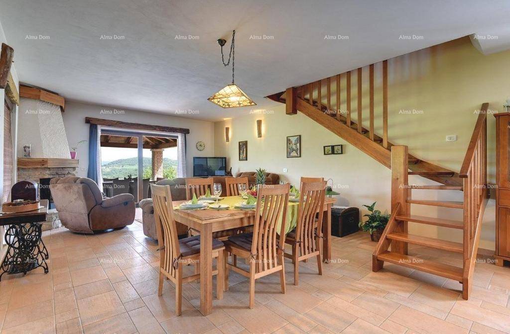 Geräumiger Wohn- und Essbereich mit Holztisch, Treppe und Blick auf den Kamin, ideal für Familien.