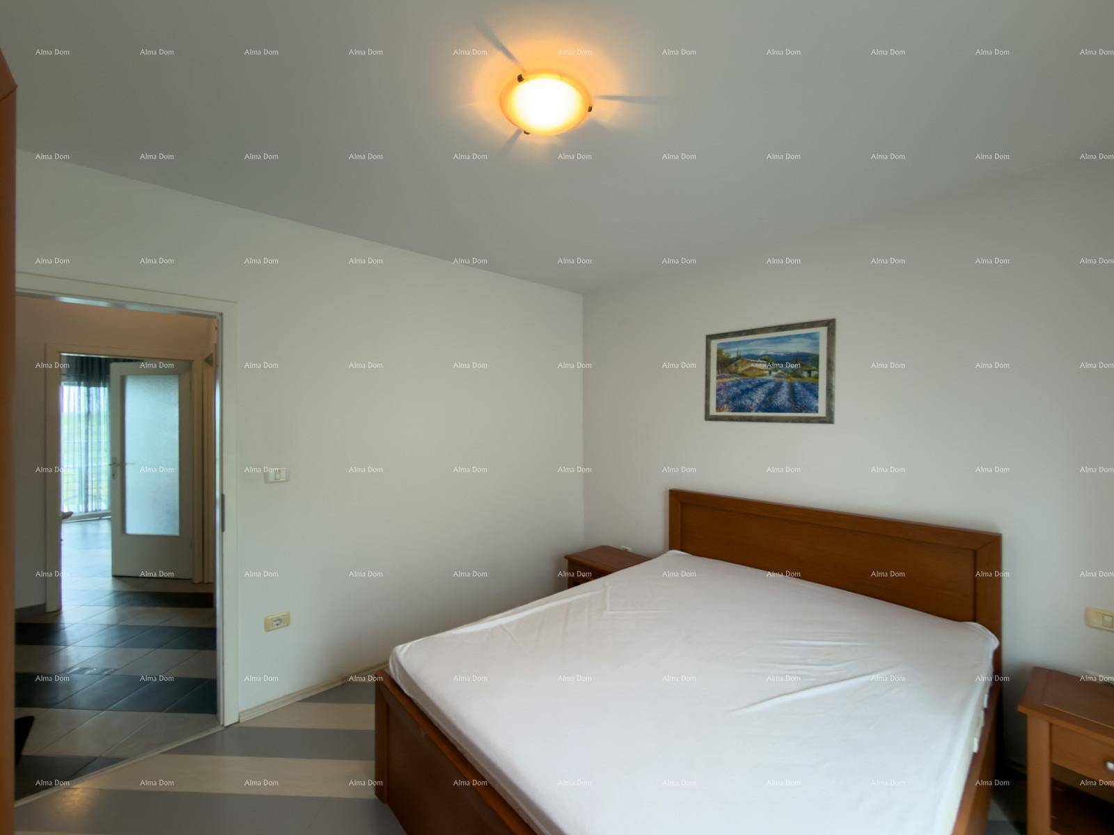 Schlafzimmer mit Holzbett und Nachttischen, angrenzend an einen weiteren Wohnbereich.
