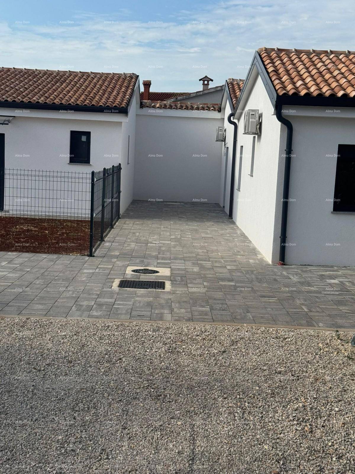 Seitenansicht des Hauses mit gepflasterter Zufahrt und traditionellen Ziegeldächern.