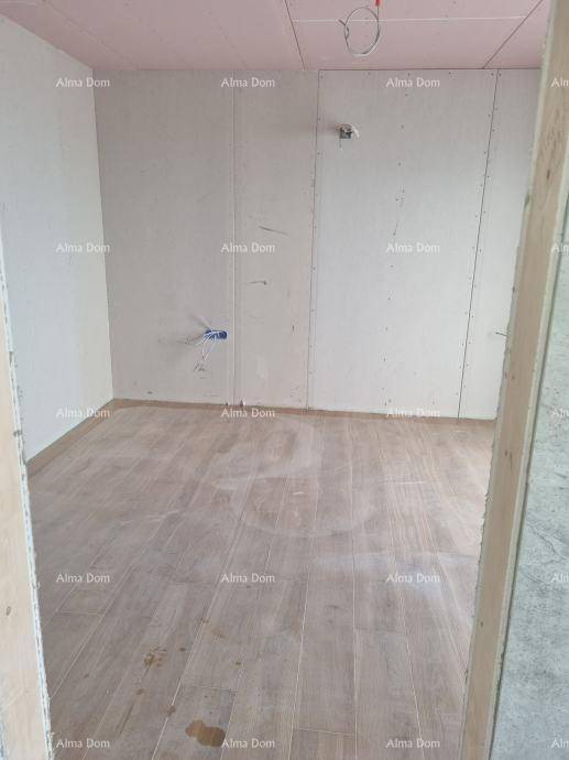 Kleiner Raum im Rohbau mit holzfarbenem Bodenbelag und vorbereiteten Anschlüssen.