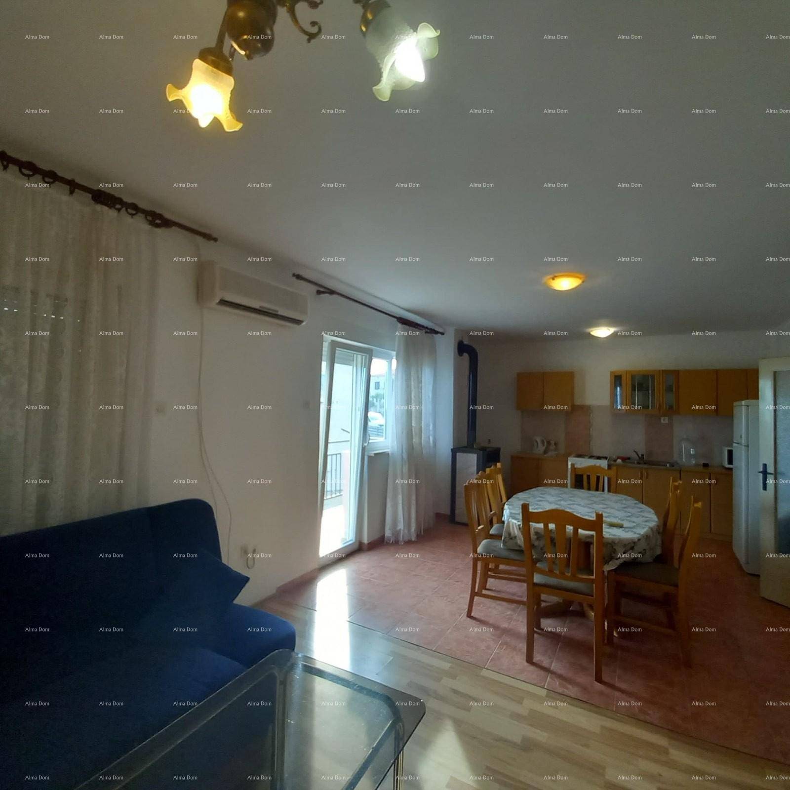 Offener Wohn- und Essbereich mit Sofa, Esstisch und Zugang zu einem Balkon.