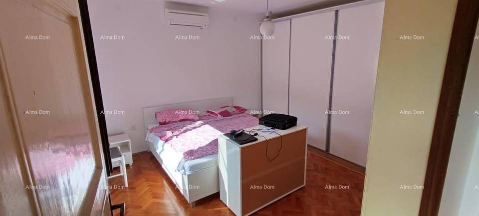Schlafzimmer mit Doppelbett, großem Kleiderschrank, Klimaanlage und Holzboden.