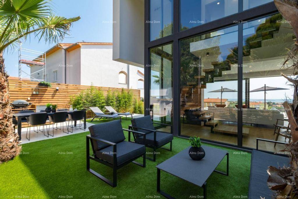 Heller Gartenbereich mit Essplatz im Freien und Blick auf die beeindruckende Glasfassade der Villa.