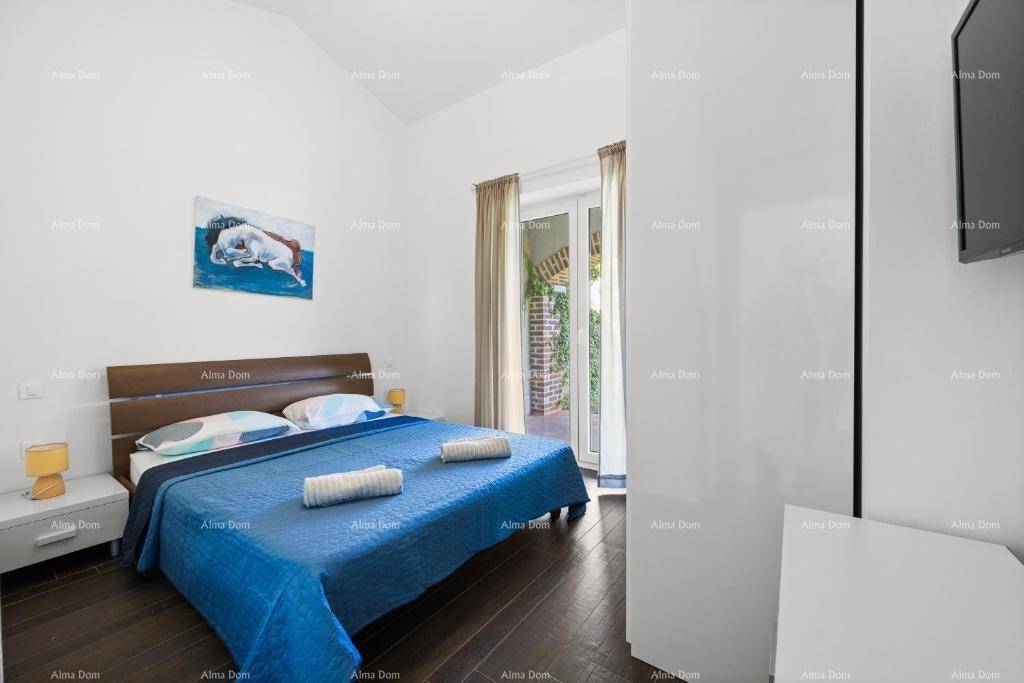 Schlafzimmer mit Doppelbett, dunklem Holzboden und Zugang zu einem Außenbereich.
