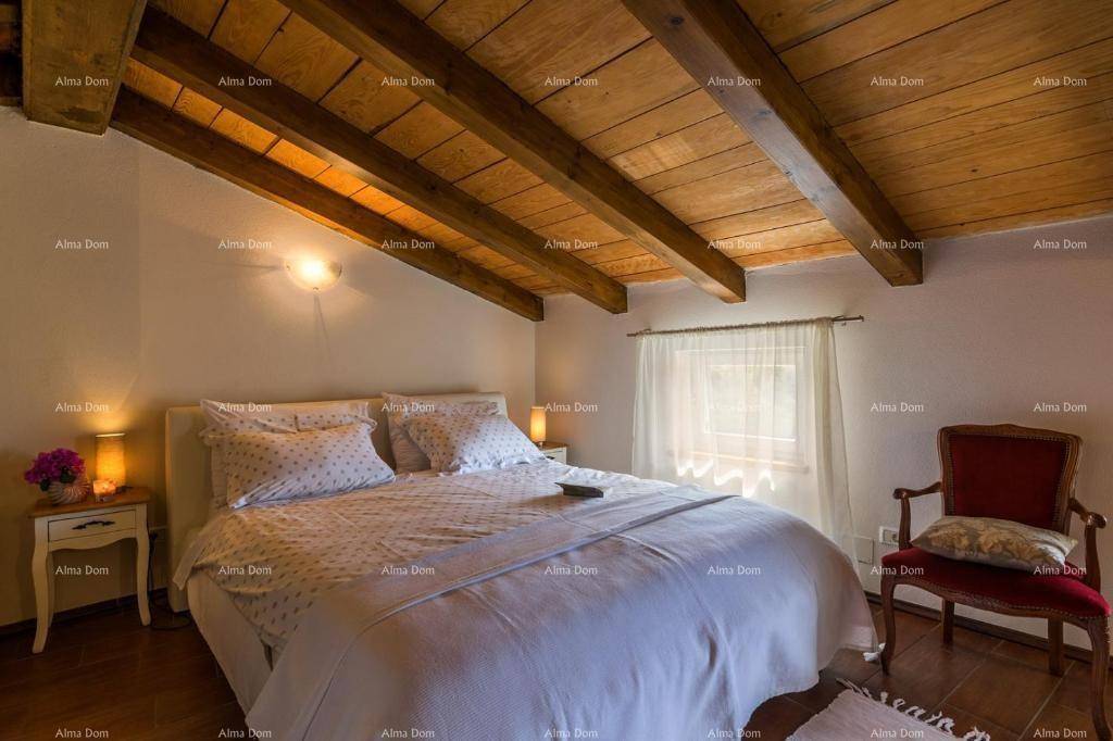 Helles Schlafzimmer im Dachgeschoss mit Holzbalken, Holzboden und Fenster.