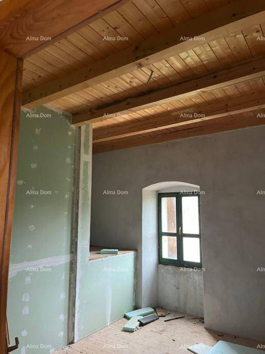 Renovierungsbedürftiger Raum mit sichtbaren Holzbalken, Holzdielenboden und einem kleinen Fenster.