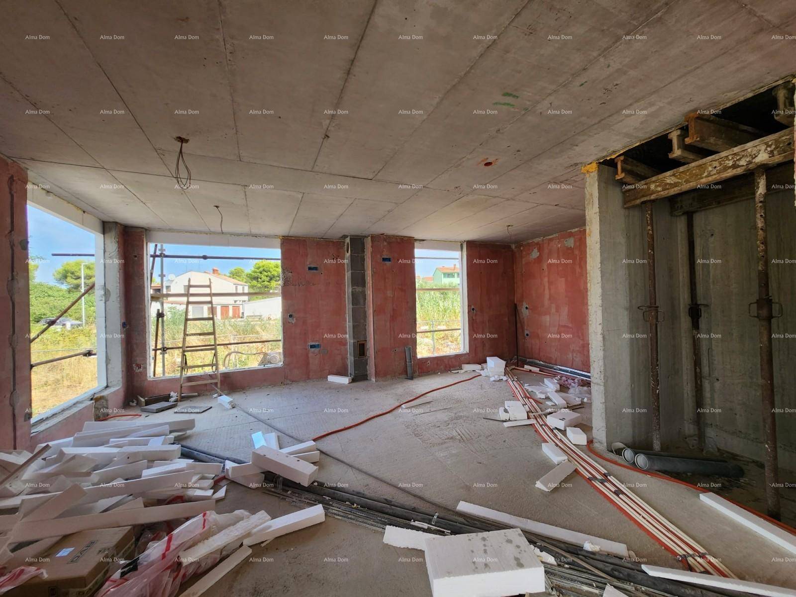 Großer Raum im Rohbau mit unverputzten Wänden, Betonboden und mehreren großen Fensteröffnungen.
