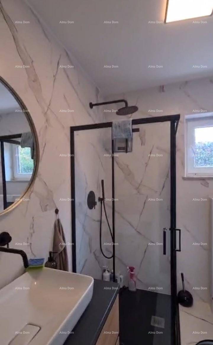 Modernes Badezimmer mit begehbarer Dusche, Marmorfliesen und rundem Spiegel.